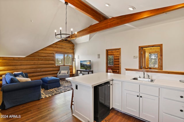 kitchen with log walls, sink, vaulted ceiling, dark wood-type flooring, and a notable chandelier