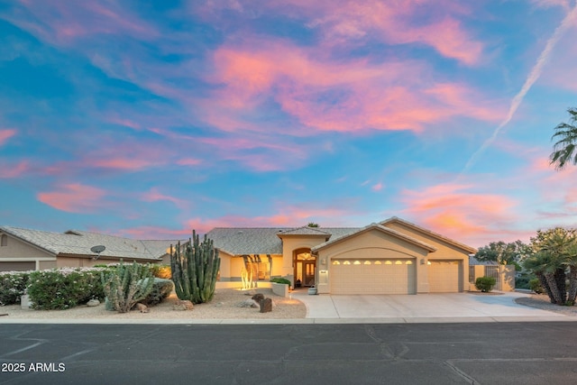 ranch-style house featuring an attached garage, driveway, and stucco siding