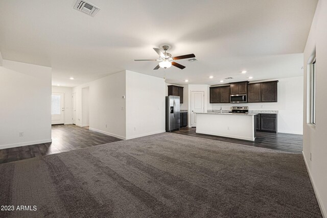 interior space with light countertops, visible vents, appliances with stainless steel finishes, open floor plan, and dark brown cabinets