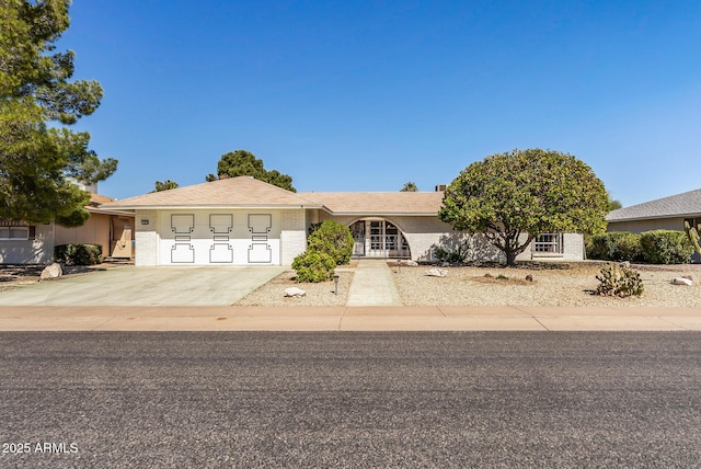 single story home with brick siding, driveway, and an attached garage