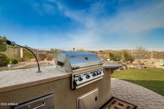 view of patio with area for grilling and a fenced backyard