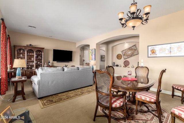 dining room with baseboards, arched walkways, visible vents, and a chandelier