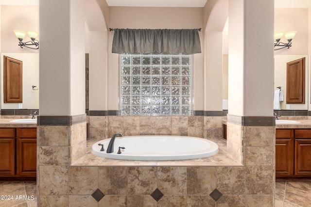 bathroom with tile patterned floors, a sink, a garden tub, and two vanities