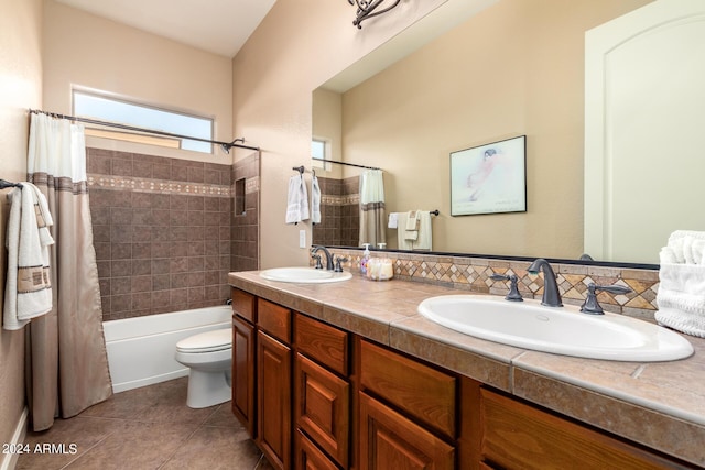 full bath with a sink, toilet, double vanity, and tile patterned flooring