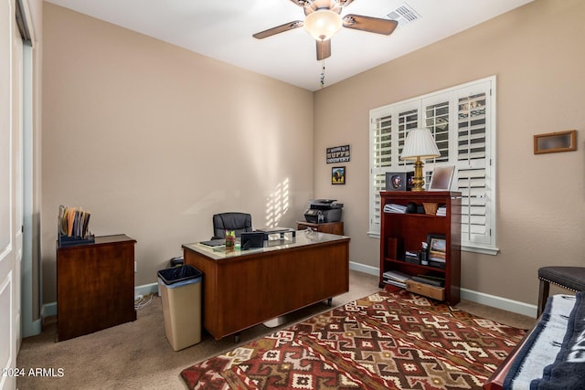 carpeted office with visible vents, baseboards, and a ceiling fan