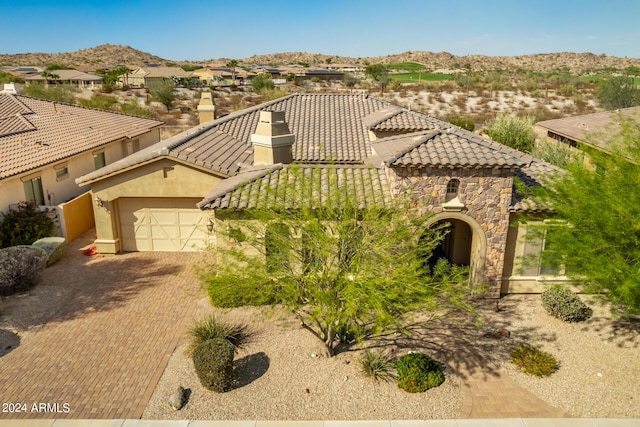 mediterranean / spanish-style home with stucco siding, a mountain view, a tile roof, and decorative driveway