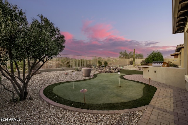 view of property's community with a patio area, area for grilling, and a fenced backyard