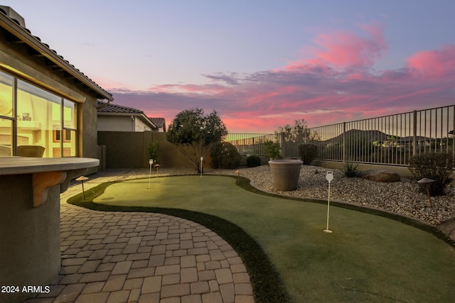 yard at dusk featuring a patio and a fenced backyard