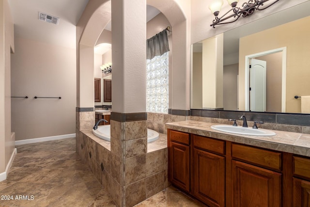 full bath with vanity, a garden tub, baseboards, and visible vents