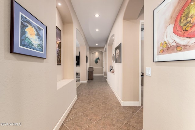 hall featuring arched walkways, tile patterned flooring, recessed lighting, and baseboards