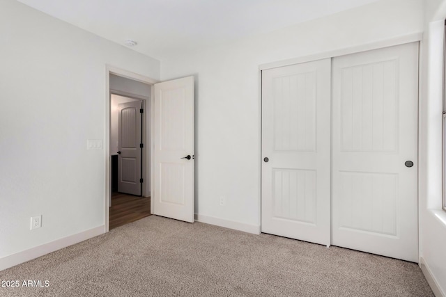 unfurnished bedroom featuring light colored carpet and a closet