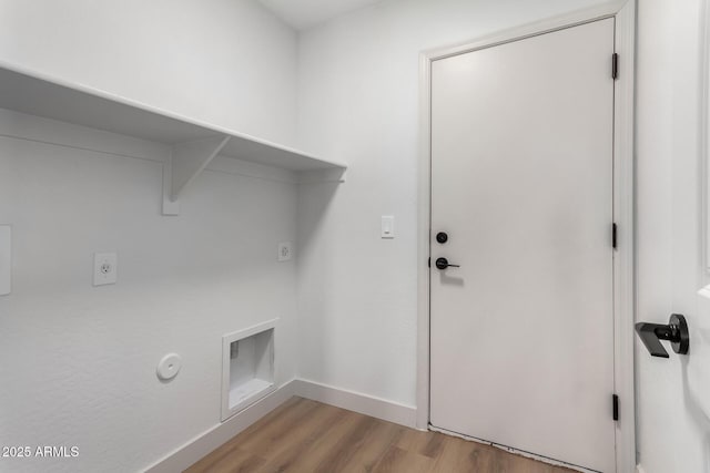 washroom featuring light wood-type flooring, hookup for a gas dryer, and hookup for an electric dryer