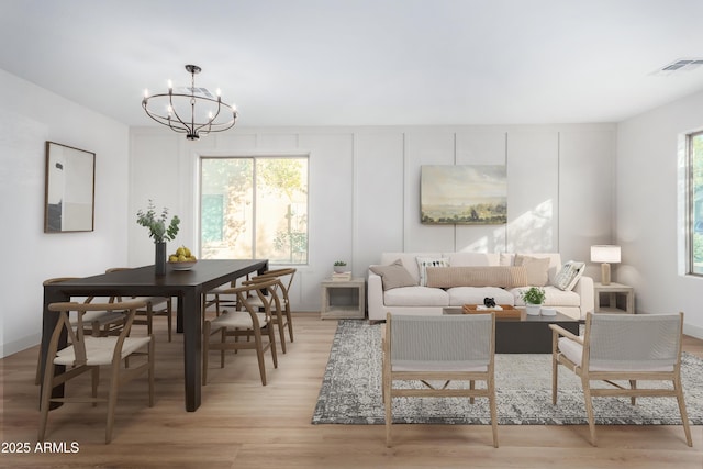 living room featuring an inviting chandelier and light hardwood / wood-style floors