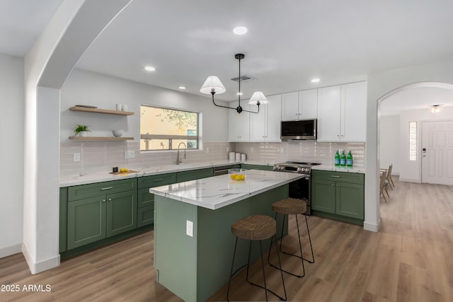 kitchen featuring green cabinets, sink, white cabinetry, a kitchen island, and stainless steel appliances