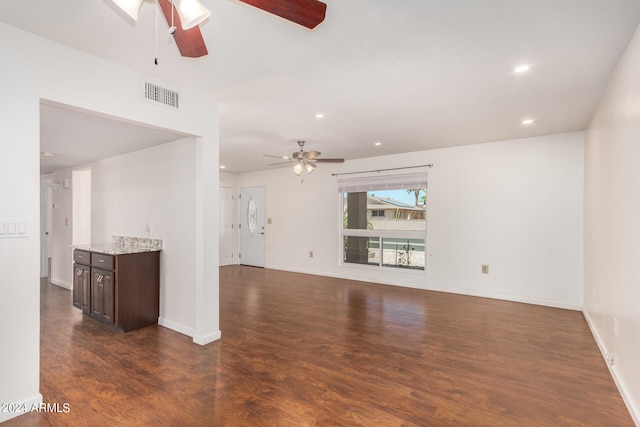 unfurnished living room with ceiling fan and dark wood-type flooring