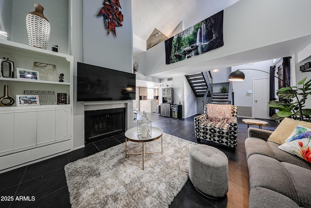 6533 N 10th Pl, Phoenix, AZ 85014 - tiled living room featuring stairs, high vaulted ceiling, and a fireplace with flush hearth