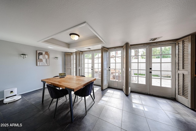6533 N 10th Pl, Phoenix, AZ 85014 - tiled dining area featuring french doors, a tray ceiling, plenty of natural light, baseboards, and a textured ceiling