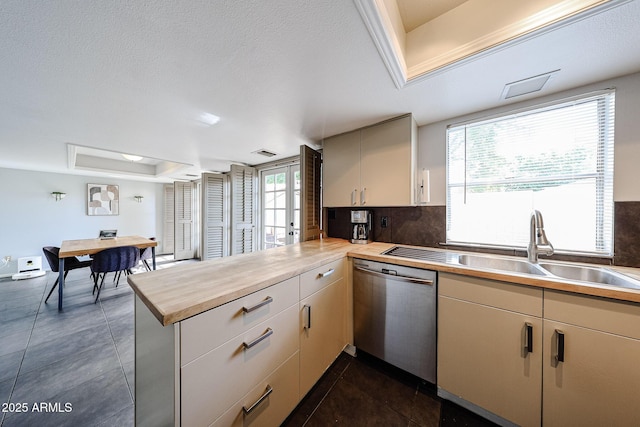 6533 N 10th Pl, Phoenix, AZ 85014 - kitchen featuring dishwasher, a tray ceiling, a peninsula, wood counters, and a sink