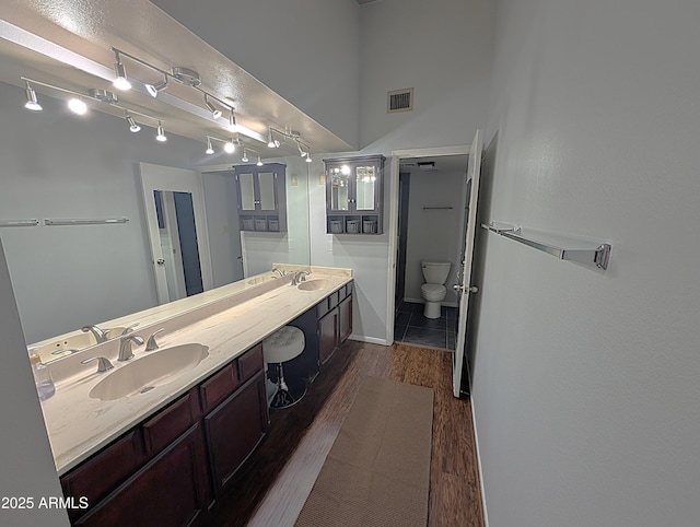 6533 N 10th Pl, Phoenix, AZ 85014 - full bath with double vanity, wood finished floors, toilet, and baseboards