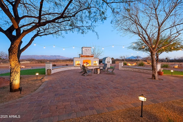 exterior space with an outdoor brick fireplace and a mountain view