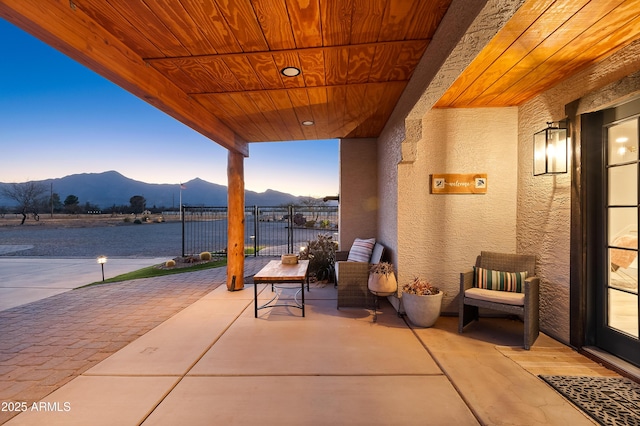 patio terrace at dusk with a water and mountain view