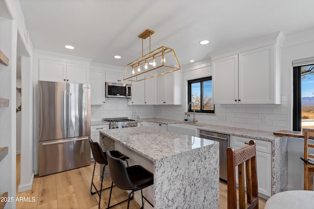 kitchen with stainless steel appliances, a center island, sink, and white cabinets