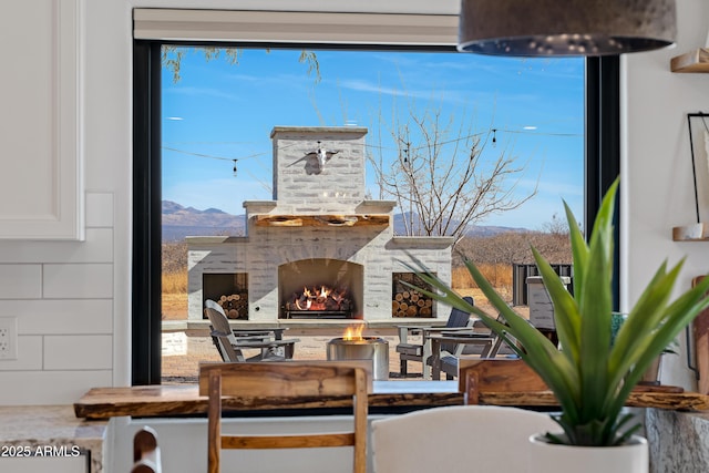 view of patio / terrace featuring a mountain view and an outdoor stone fireplace