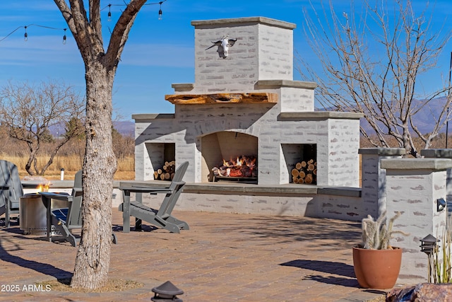 view of patio with an outdoor brick fireplace