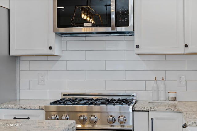 kitchen featuring white cabinetry, light stone countertops, and appliances with stainless steel finishes