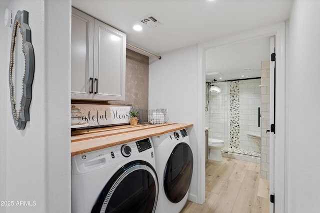 laundry area with separate washer and dryer and light hardwood / wood-style floors