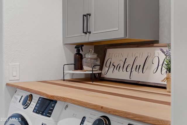 washroom with cabinets and washing machine and clothes dryer