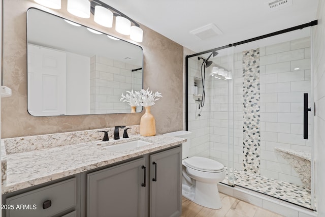 bathroom featuring vanity, toilet, and walk in shower