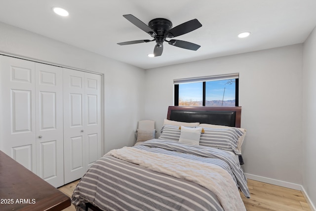 bedroom with ceiling fan, light hardwood / wood-style floors, and a closet