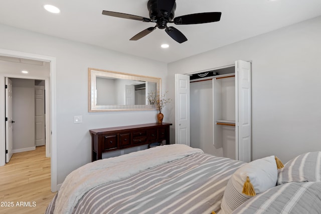 bedroom with ceiling fan, light wood-type flooring, and a closet