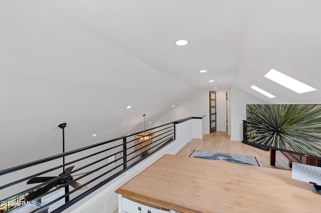 interior space with lofted ceiling with skylight and light hardwood / wood-style flooring