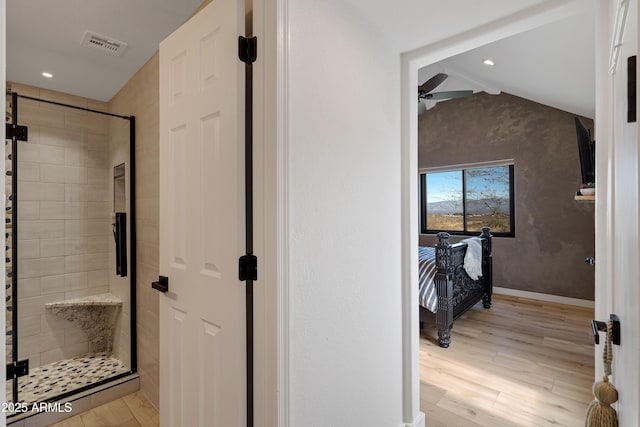 bathroom featuring hardwood / wood-style flooring, vaulted ceiling, an enclosed shower, and ceiling fan