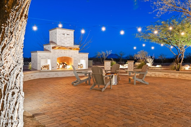 patio at twilight with an outdoor brick fireplace