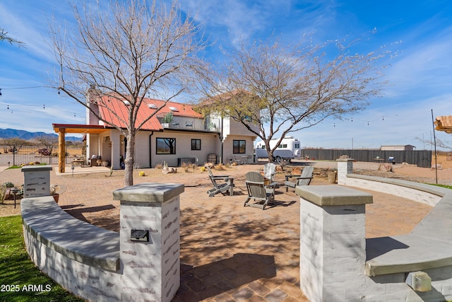 view of patio / terrace with a mountain view and an outdoor fire pit