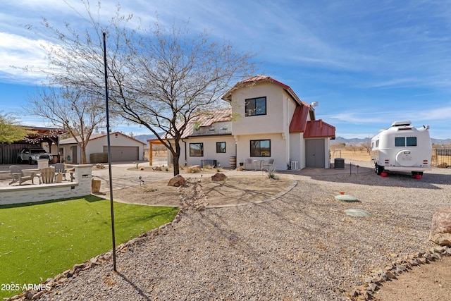 view of front of property with a garage, a patio area, and central AC