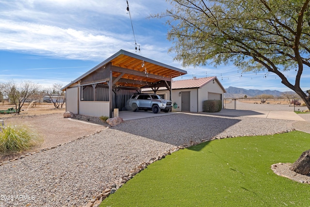 exterior space featuring a garage, a mountain view, and an outbuilding