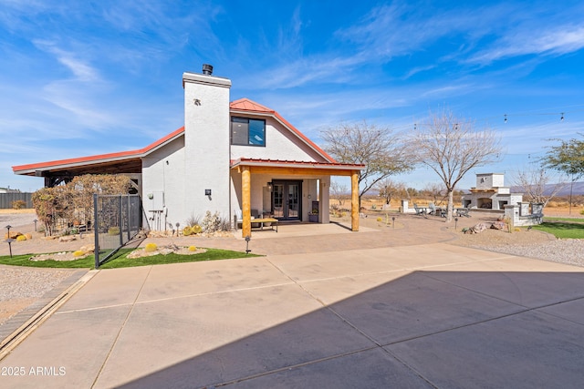 rear view of property featuring a fireplace and a patio area