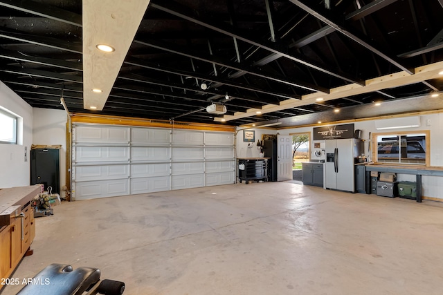 garage with a garage door opener and stainless steel fridge