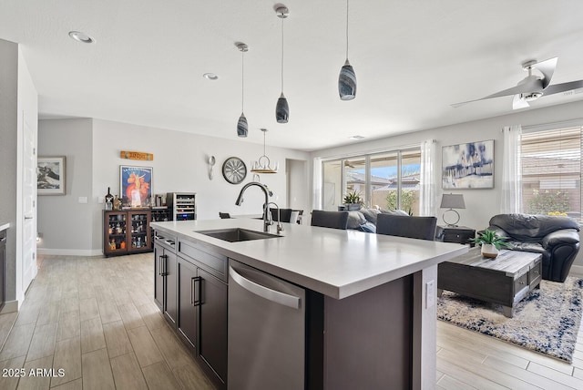 kitchen with a sink, open floor plan, light wood-style flooring, and dishwasher