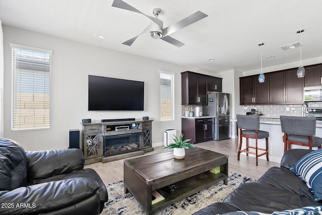 living area featuring visible vents, recessed lighting, light wood-style flooring, and ceiling fan