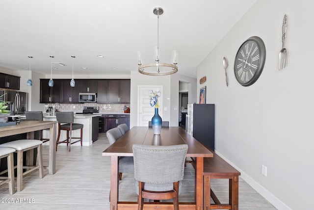 dining space featuring baseboards, recessed lighting, and light wood-style flooring