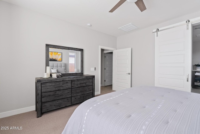 carpeted bedroom with baseboards, visible vents, a barn door, and ceiling fan
