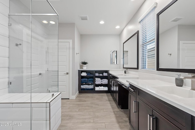 bathroom with visible vents, double vanity, recessed lighting, a sink, and a stall shower