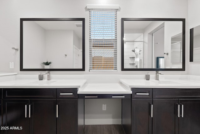 full bathroom featuring a sink, two vanities, and tiled shower