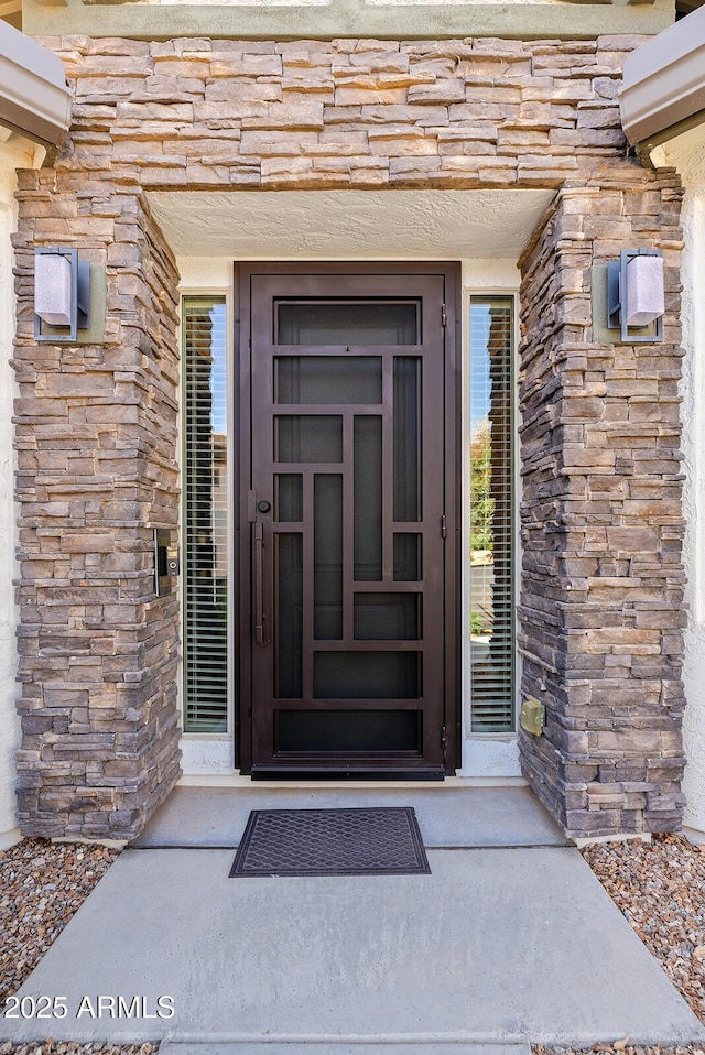 property entrance with stone siding