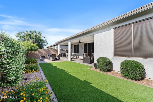 view of yard featuring a patio, a ceiling fan, and fence